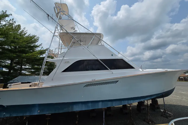 Slide: The Image of 1986 Ocean Yachts 55 Super Sport boat on stands under cloudy sky. - 7