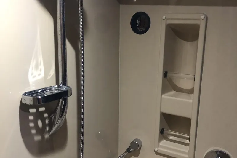 Slide: The Image of 2006 Cruisers Yachts 420 Express bathroom with shower fixtures and built-in shelving. - 12