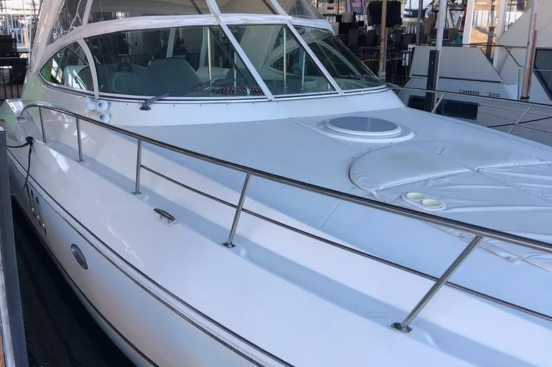 Slide: The Image of 2006 Cruisers Yachts 420 Express, sleek white exterior, docked in marina. - 16