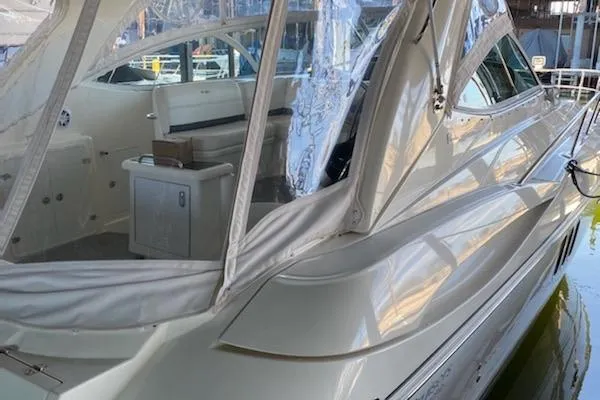 Slide: The Image of 2006 Cruisers Yachts 420 Express, sleek design, docked with covered seating area. - 17