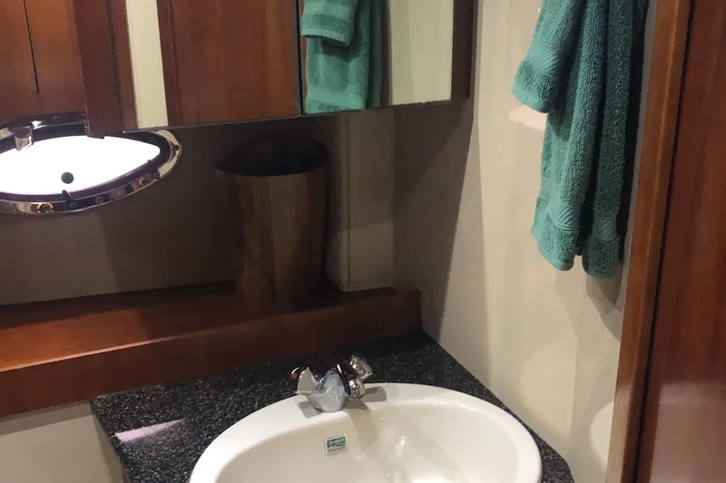 Slide: The Image of Bathroom interior of 2006 Cruisers Yachts 420 Express with sink and teal towels. - 18