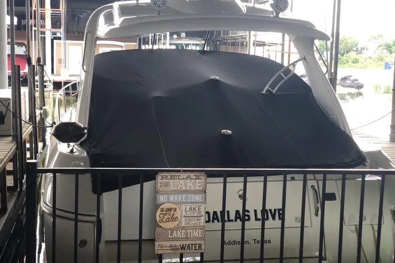 Slide: The Image of 2006 Cruisers Yachts 420 Express docked with cover, sign reading "Relax at the Lake." - 21