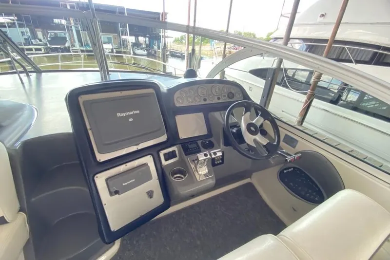 Slide: The Image of 2006 Cruisers Yachts 420 Express helm with Raymarine navigation system and steering wheel. - 26