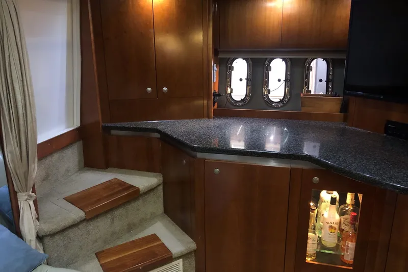 Slide: The Image of 2006 Cruisers Yachts 420 Express interior with wooden cabinetry and granite countertop. - 31