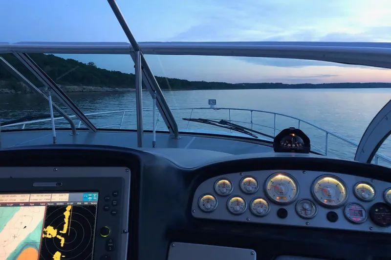 Slide: The Image of 2006 Cruisers Yachts 420 Express dashboard view at sunset on calm waters. - 4