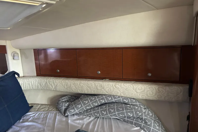 Slide: The Image of Interior cabin of 2005 Sea Ray 340 Sundancer with wooden cabinets and bedding. - 10
