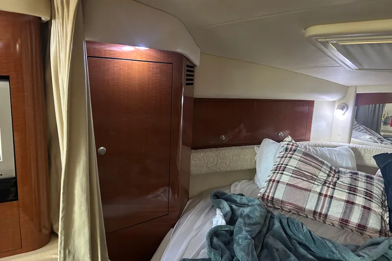 Slide: The Image of Cozy cabin interior of 2005 Sea Ray 340 Sundancer with wood paneling and plaid bedding. - 11