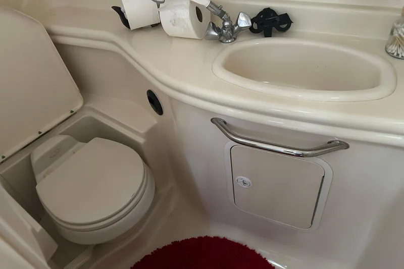 Slide: The Image of 2005 Sea Ray 340 Sundancer bathroom with toilet, sink, and storage cabinet. - 13