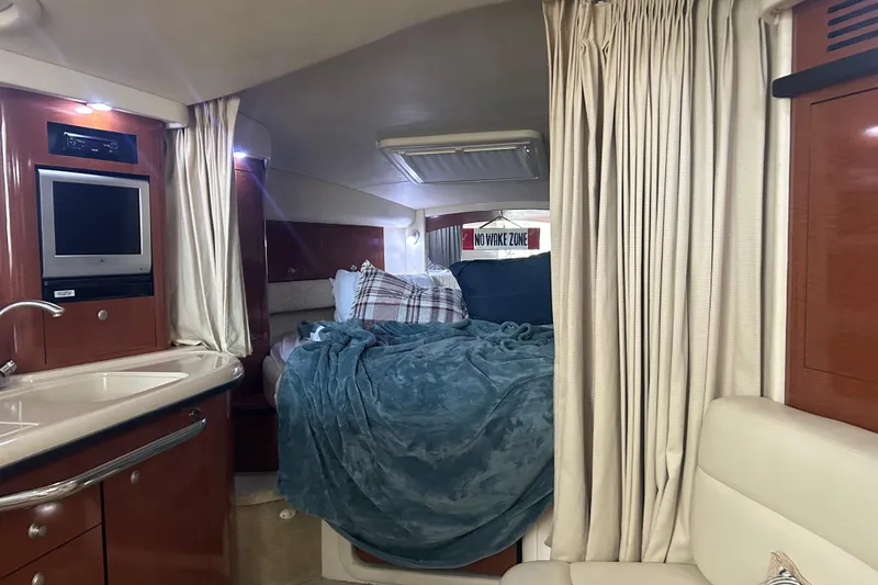 Slide: The Image of 2005 Sea Ray 340 Sundancer cabin interior with cozy bed and kitchenette. - 16