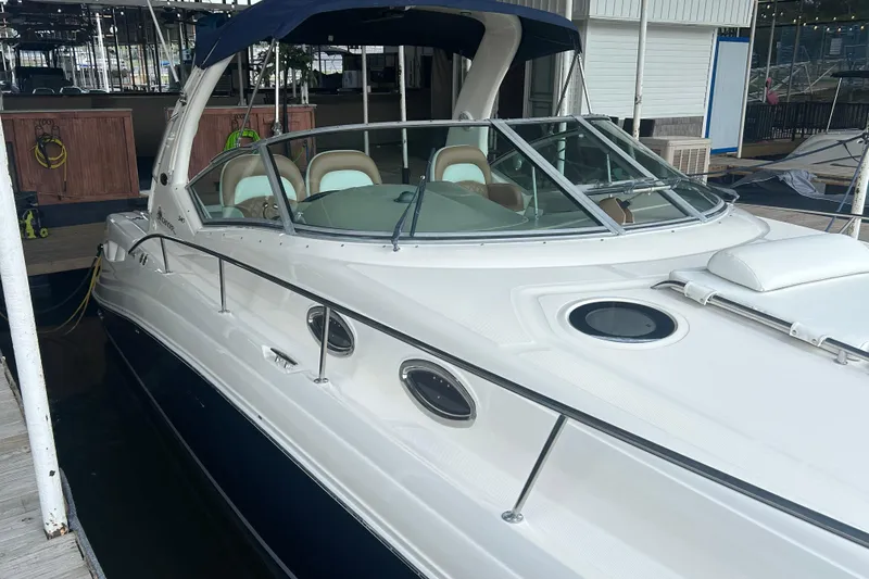 Slide: The Image of 2005 Sea Ray 340 Sundancer docked, featuring sleek design and spacious cockpit. - 2