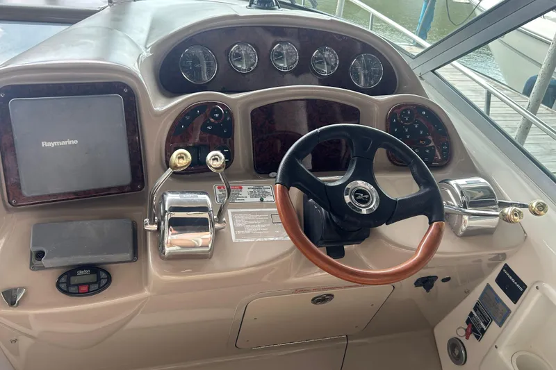 Slide: The Image of 2005 Sea Ray 340 Sundancer helm with steering wheel and navigation controls. - 22
