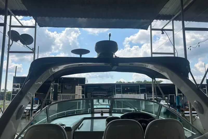 Slide: The Image of 2005 Sea Ray 340 Sundancer boat docked under a canopy with a clear sky. - 25