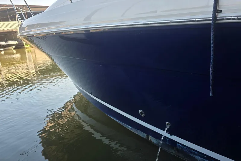 Slide: The Image of 2005 Sea Ray 340 Sundancer boat docked, showing sleek blue hull design. - 42