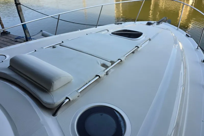 Slide: The Image of 2005 Sea Ray 340 Sundancer boat deck with sunpad and railing by the water. - 47