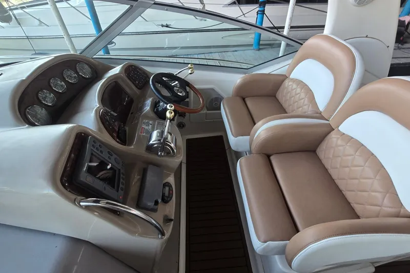 Slide: The Image of 2005 Sea Ray 340 Sundancer helm with dual seats and modern dashboard controls. - 50