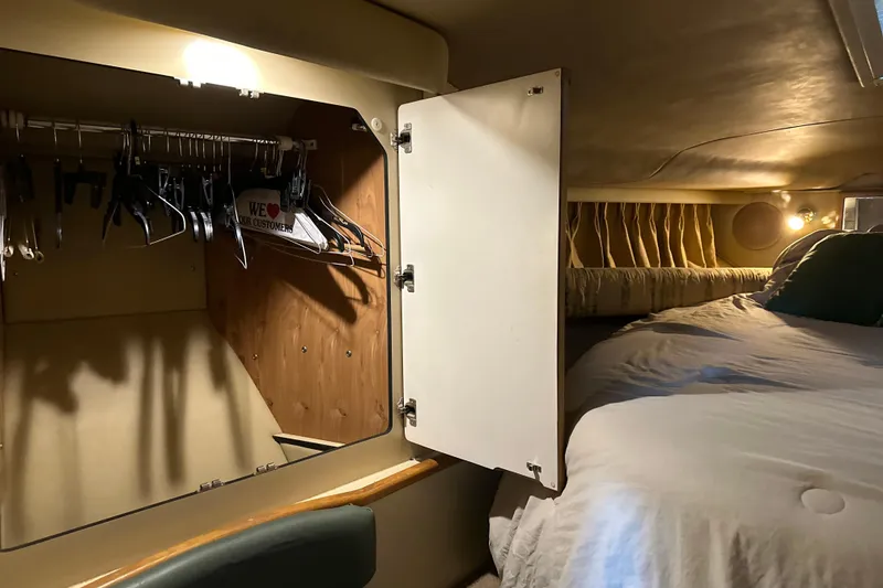 Slide: The Image of Cozy cabin interior of 2005 Sea Ray 340 Sundancer with open closet and bed. - 52