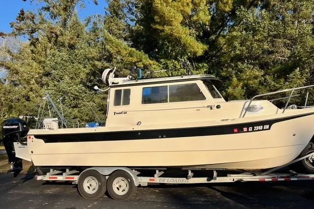 Slide: The Image of 2007 C-Dory Tomcat 255 Pilothouse boat on trailer, surrounded by trees. - 0