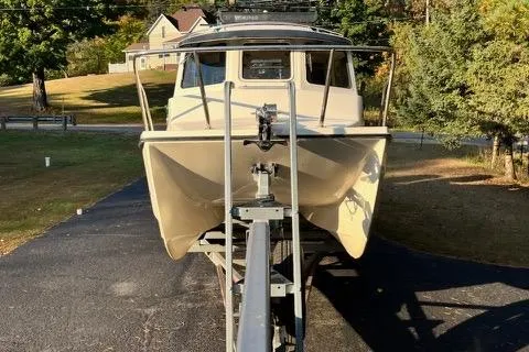 Slide: The Image of 2007 C-Dory Tomcat 255 Pilothouse boat on trailer, parked in driveway. - 1