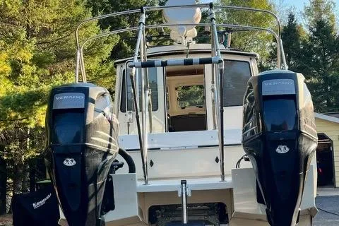 Slide: The Image of 2007 C-Dory Tomcat 255 Pilothouse with dual outboard engines, docked outdoors. - 2