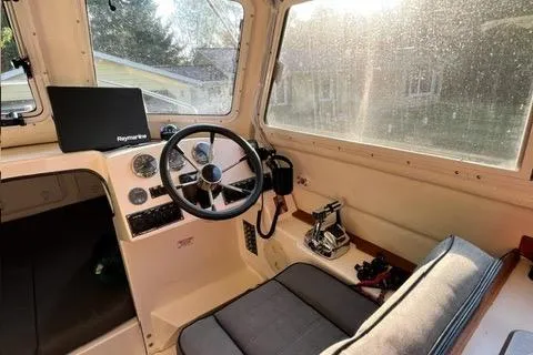 Slide: The Image of 2007 C-Dory Tomcat 255 Pilothouse interior with steering wheel and control panel. - 3