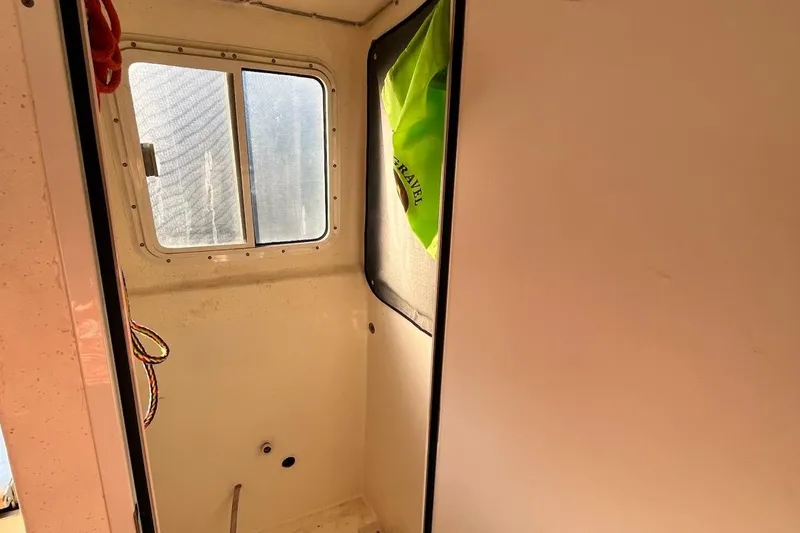 Slide: The Image of 2007 C-Dory Tomcat 255 Pilothouse interior with window and storage area. - 9