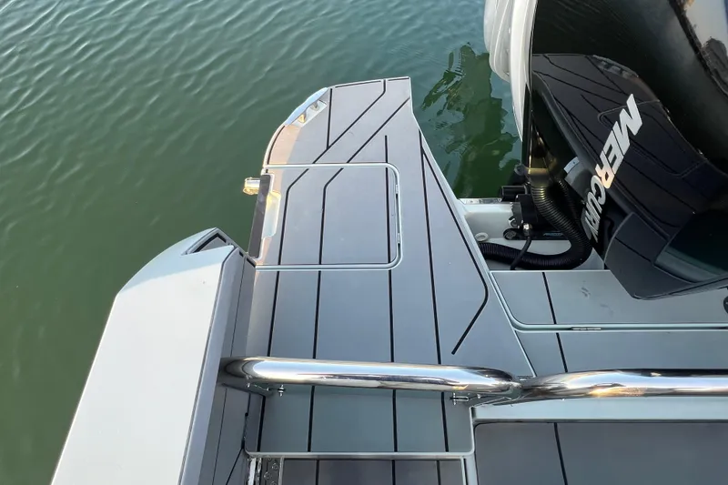 Slide: The Image of 2023 Saxdor 320 GTO boat deck with Mercury engine, sleek design on calm water. - 15
