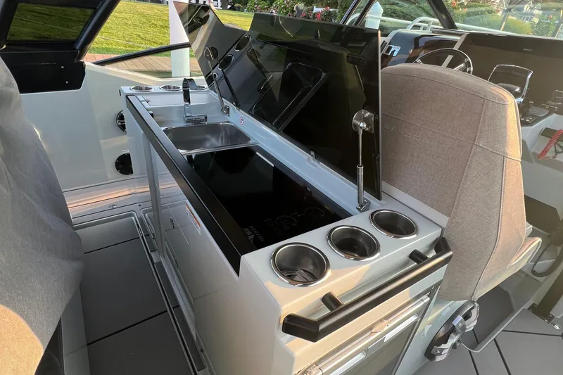Slide: The Image of 2023 Saxdor 320 GTO boat interior with kitchenette and seating area. - 17