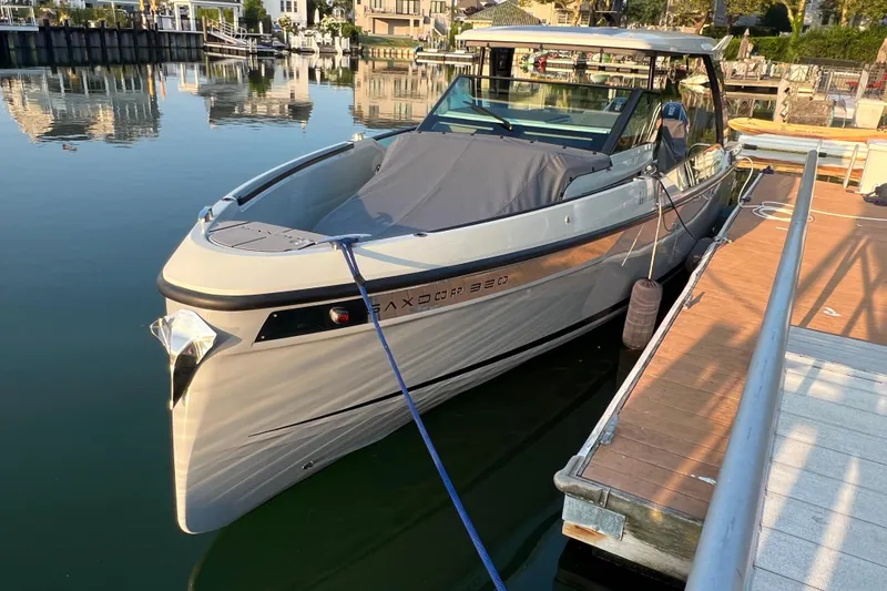 Slide: The Image of 2023 Saxdor 320 GTO boat docked at a marina, reflecting on calm water. - 3
