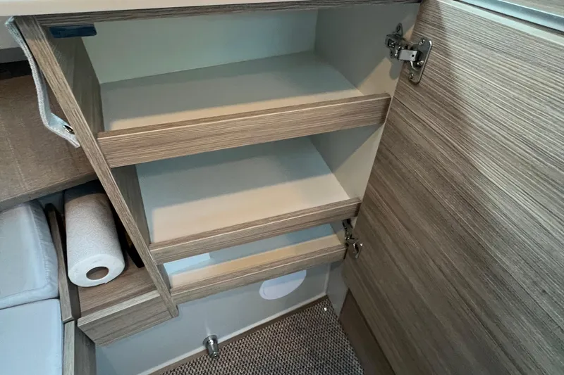 Slide: The Image of Interior storage shelves in 2023 Saxdor 320 GTO boat, featuring wood finish and open cabinet. - 36