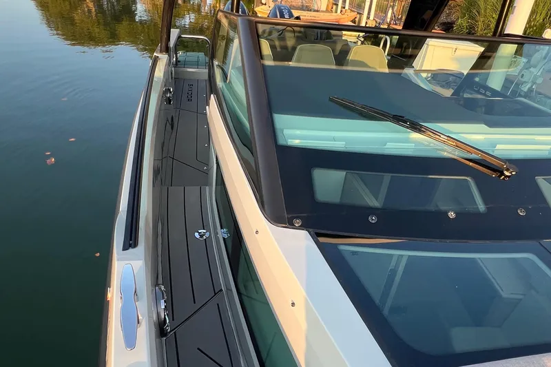 Slide: The Image of 2023 Saxdor 320 GTO boat, sleek design, docked on calm water, close-up view. - 45