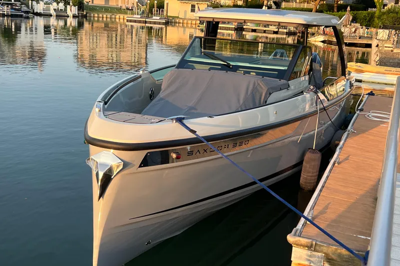 Slide: The Image of 2023 Saxdor 320 GTO boat docked at a marina, reflecting on calm water. - 48
