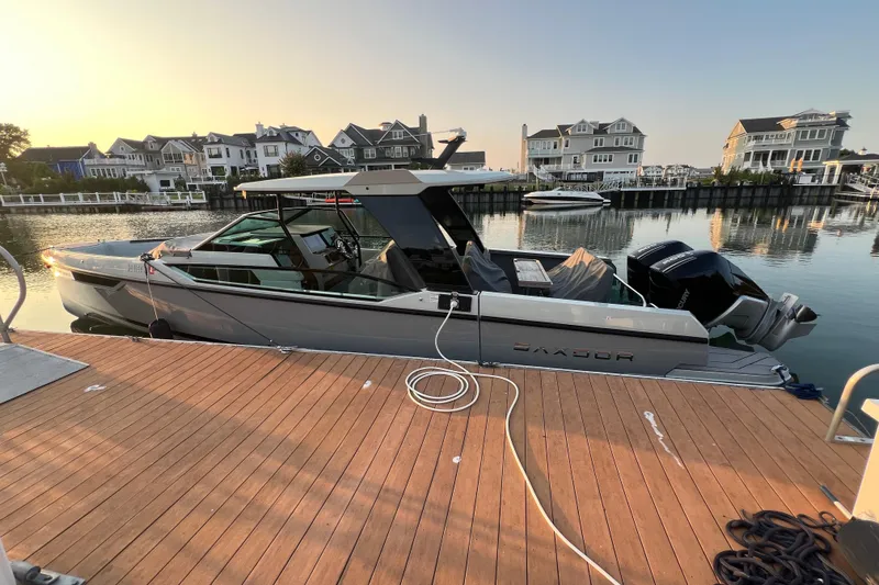 Slide: The Image of 2023 Saxdor 320 GTO docked at a marina, surrounded by waterfront homes. - 54