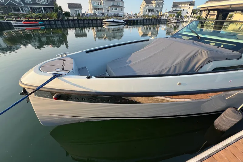 Slide: The Image of 2023 Saxdor 320 GTO boat docked in a serene marina setting. - 7