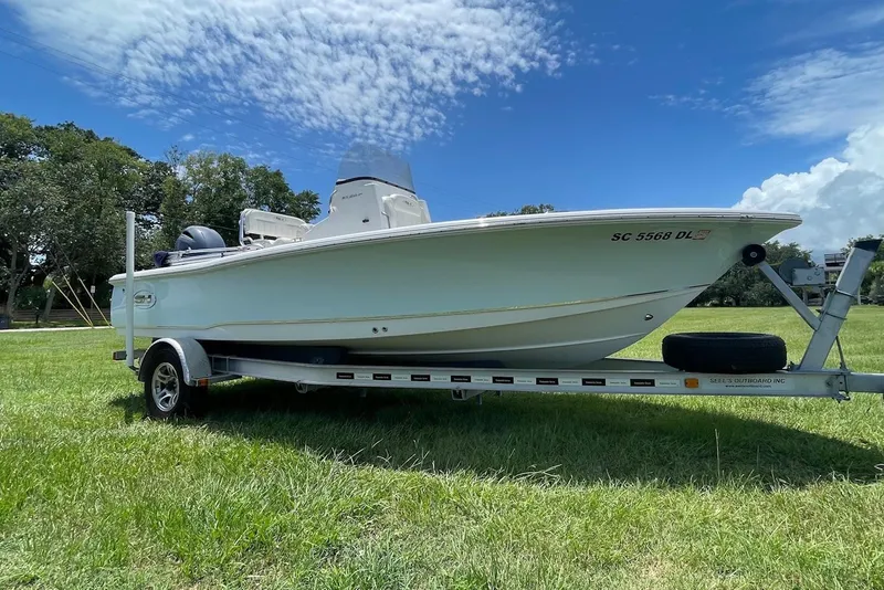 Slide: The Image of 2019 Sea Hunt BX 20 BR boat on trailer in grassy field under blue sky. - 0