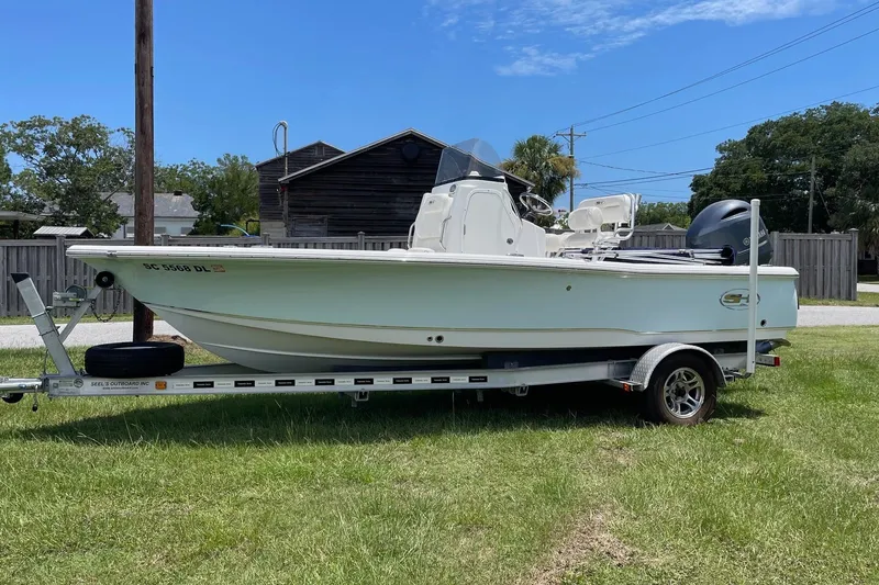 Slide: The Image of 2019 Sea Hunt BX 20 BR boat on trailer, parked on grass under clear blue sky. - 1