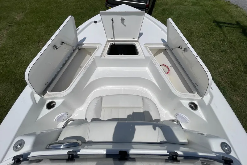 Slide: The Image of 2019 Sea Hunt BX 20 BR boat with open storage compartments on grassy background. - 14