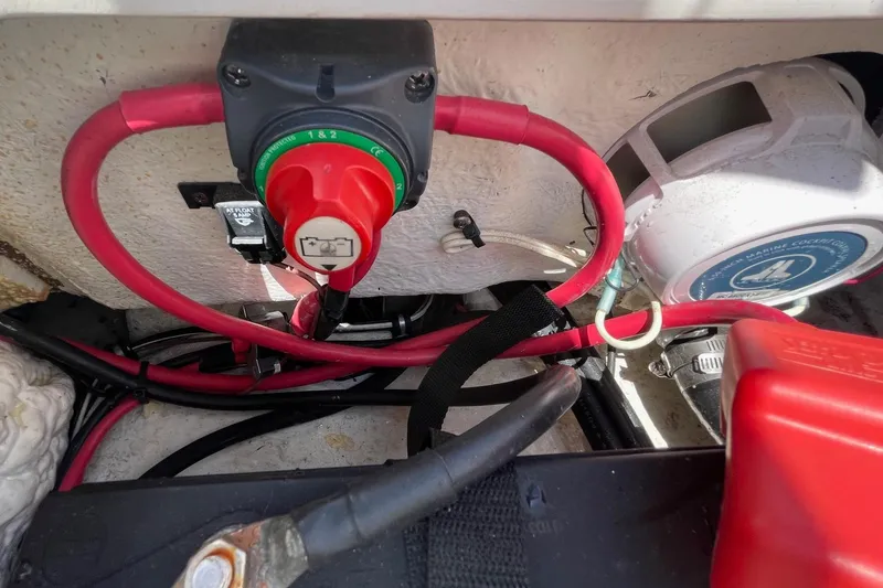 Slide: The Image of 2019 Sea Hunt BX 20 BR boat battery compartment with red cables and switch. - 30