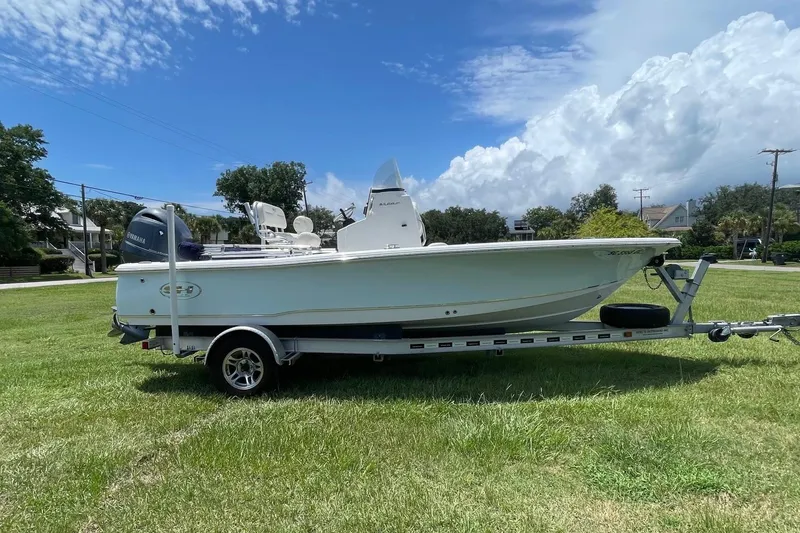Slide: The Image of 2019 Sea Hunt BX 20 BR boat on trailer, parked on grassy field under blue sky. - 4