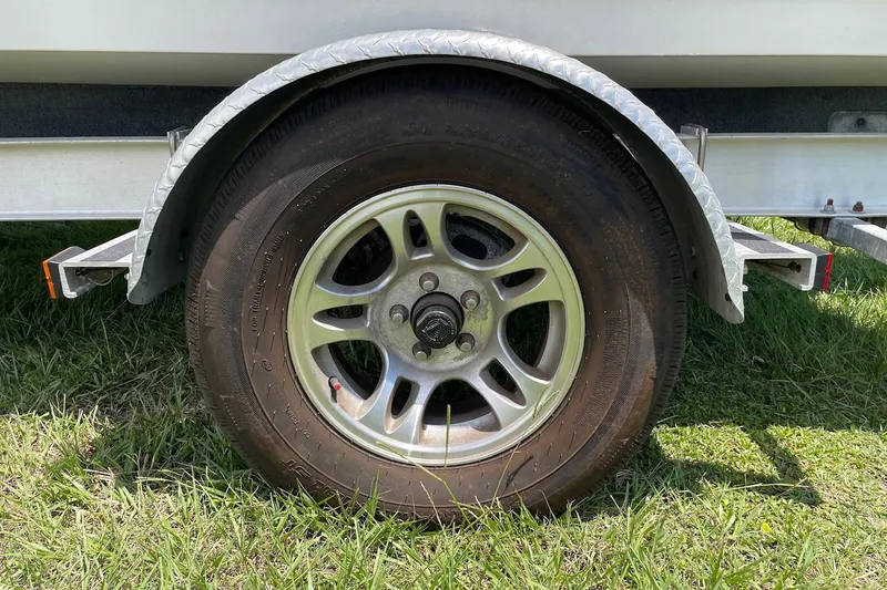 Slide: The Image of Trailer wheel of 2019 Sea Hunt BX 20 BR boat on grass. - 40
