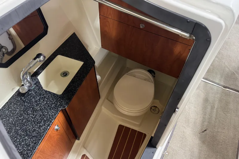 Slide: The Image of 2012 Monterey 328 SS Axius boat bathroom with sink, toilet, and wood accents. - 12