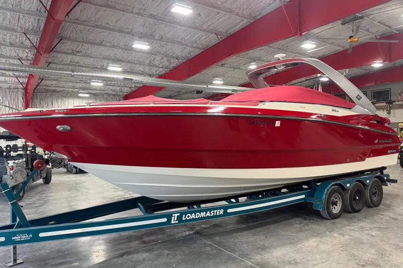 Slide: The Image of 2012 Monterey 328 SS Axius boat in red on a Loadmaster trailer indoors. - 15