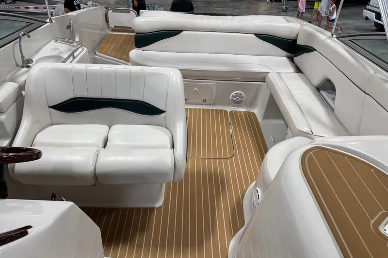 Slide: The Image of 2001 Crownline 288 BR boat interior with white seating and wood-patterned flooring. - 10