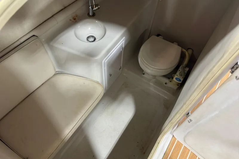 Slide: The Image of 2001 Crownline 288 BR boat interior with sink, toilet, and seating area. - 11