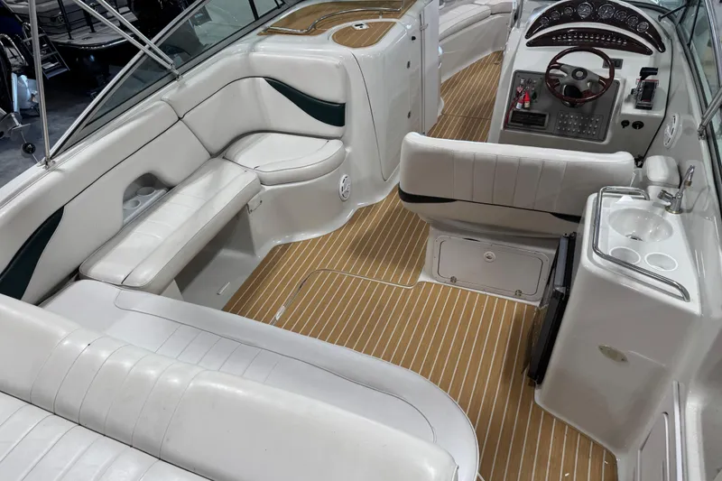Slide: The Image of 2001 Crownline 288 BR boat interior with white seating and wood-style flooring. - 7