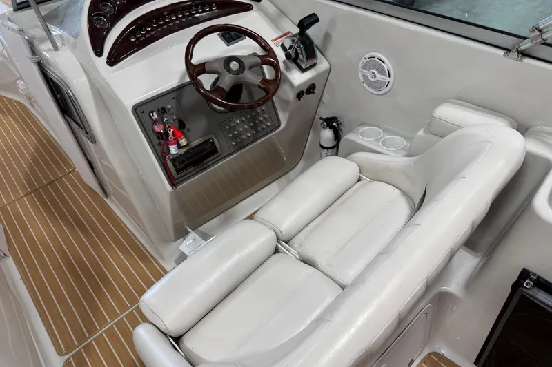 Slide: The Image of 2001 Crownline 288 BR boat interior with steering wheel, control panel, and white seating. - 8