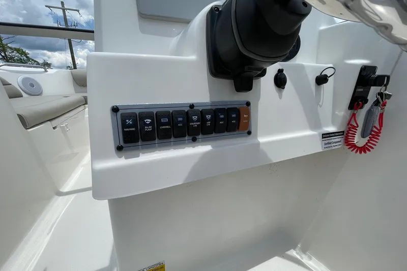 Slide: The Image of 2023 Key West 203 DFS boat dashboard with control switches and safety lanyard. - 15