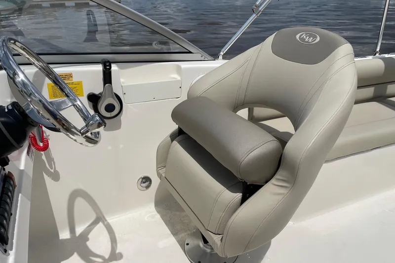 Slide: The Image of 2023 Key West 203 DFS boat interior with steering wheel and cushioned seat. - 16