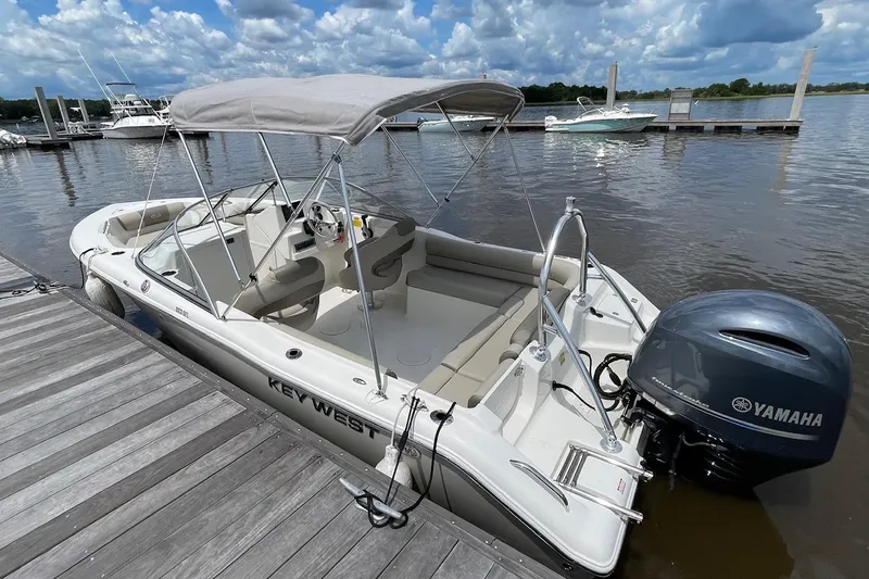 Slide: The Image of 2023 Key West 203 DFS boat docked with Yamaha engine, under cloudy sky. - 19
