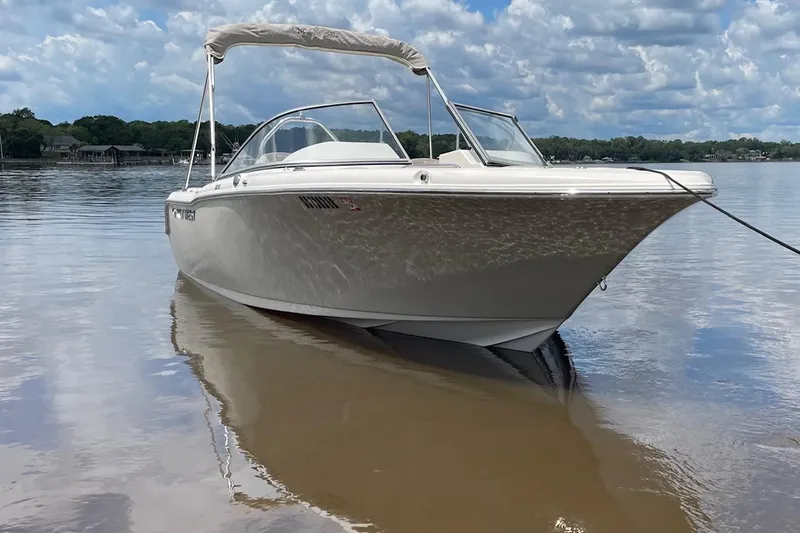 Slide: The Image of 2023 Key West 203 DFS boat on calm water under a cloudy sky. - 2