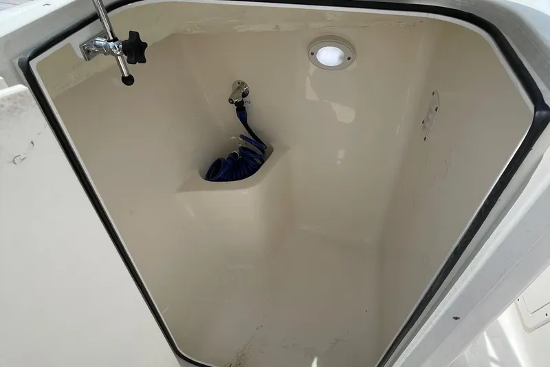 Slide: The Image of 2023 Key West 203 DFS boat storage compartment with coiled hose and light. - 20